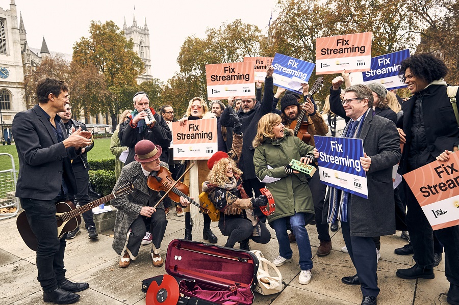 Energetic group of demonstraitors hold instruments in Parliament Square, London.