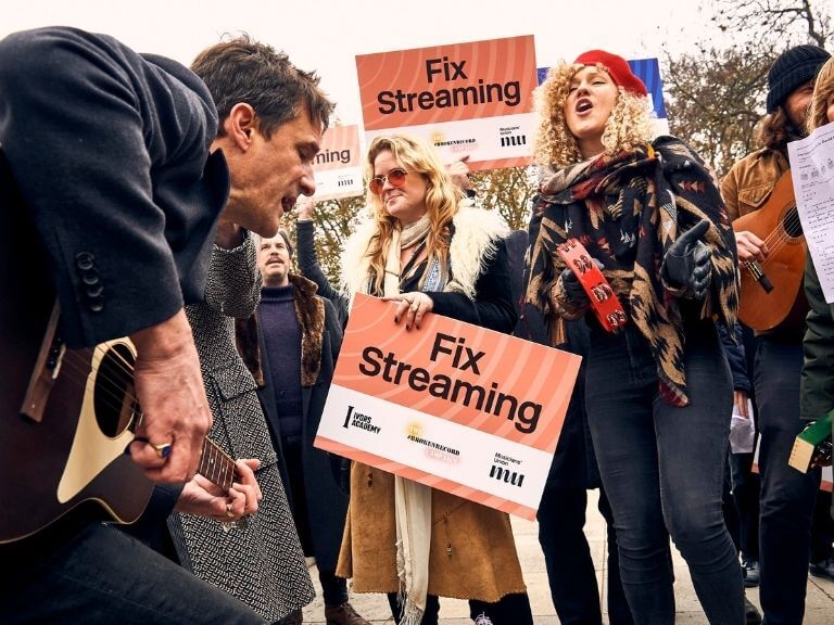 Musicians with Fix Streaming placards at the demonstration