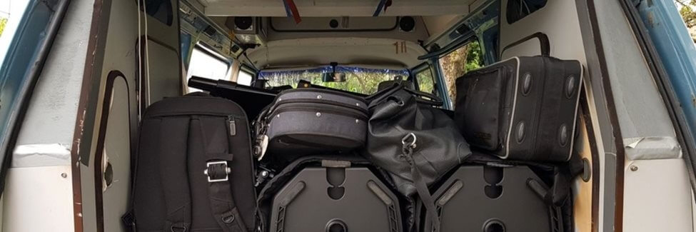 Bags, flight cases, gear piled in the boot of a small van.
