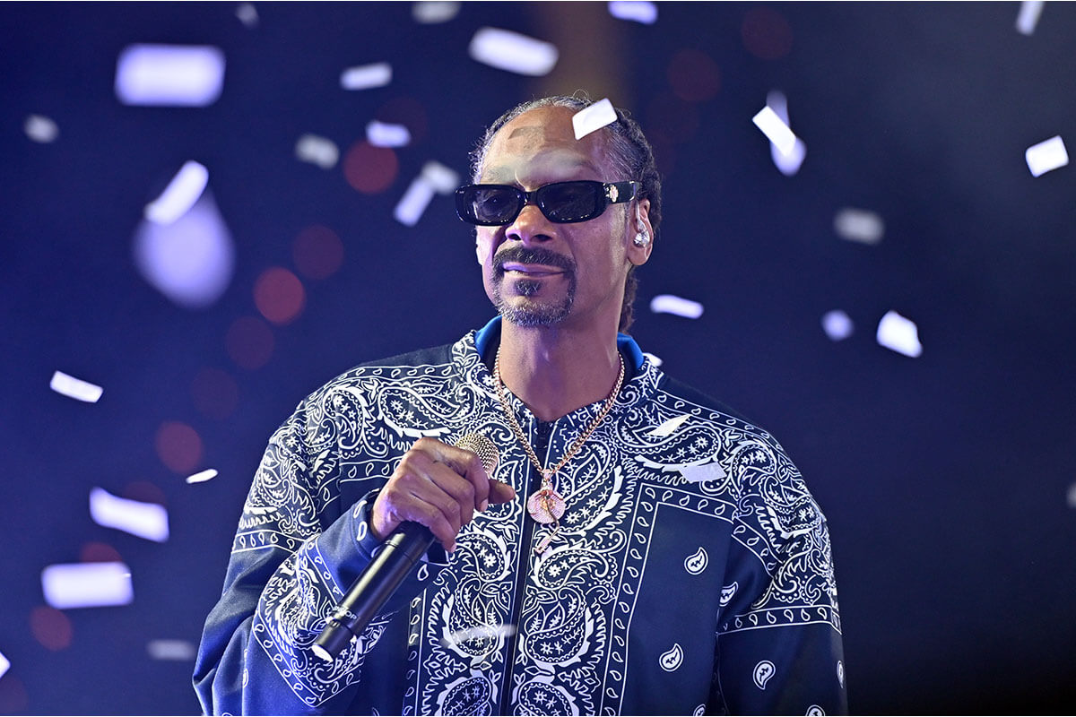 Musician snoop dog performing while bright pieces of confetti fall around him. Photo credit: Stephen J Cohen / Getty images