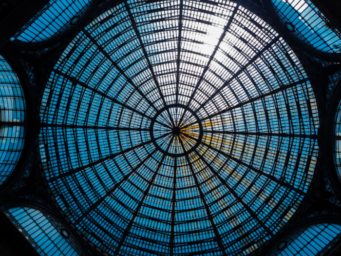 Light shines through the glass ceiling dome, with lines that spiral out in a hub like fashion