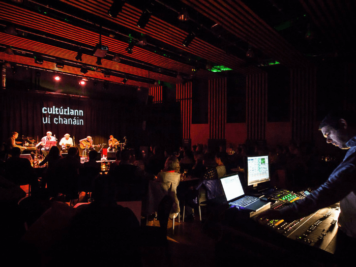 The hotel courtyard in the evening with people sitting around tables decorated with fairy lights.