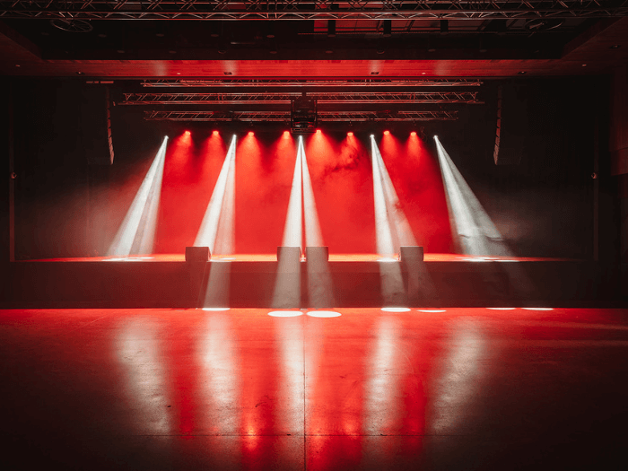 Inside of the venue. A stage with a smoke machine and red spotlights.
