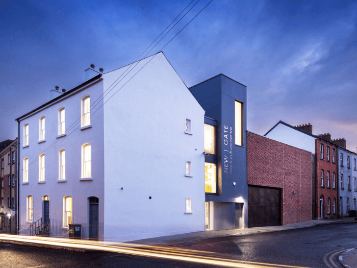 The outside of the building of New Gate Arts and Culture centre, photographed against a cloudy blue sky.