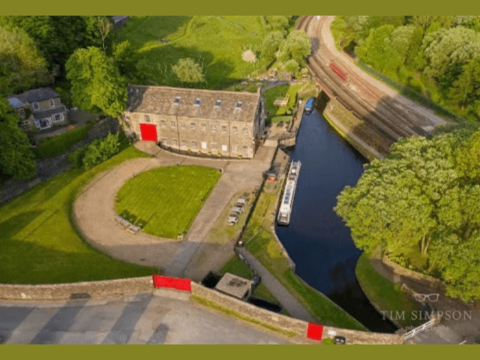 An aerial view of the North of England Centre for Music and Arts, surrounded by green rural landscape.