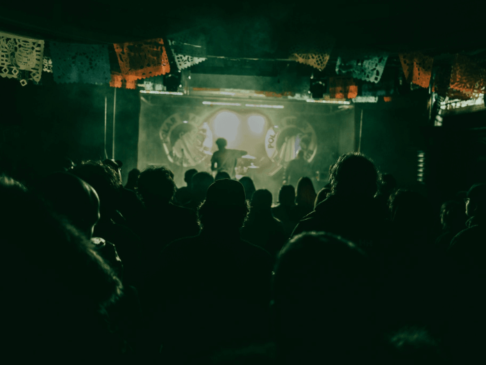 Inside of the venue, a band perform on stage.