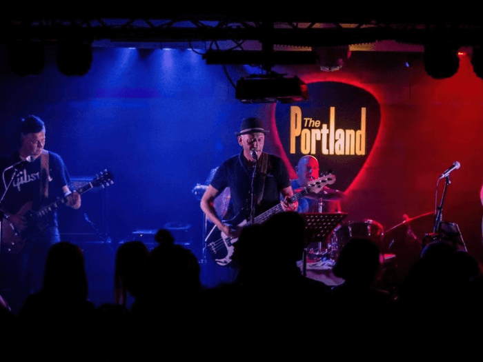 A band playing on stage at The Portland Arms.