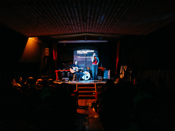 Singer and guitarist performing in front of the crowd at Theatreship in London