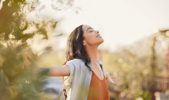 A woman smiling with outstretched arms.