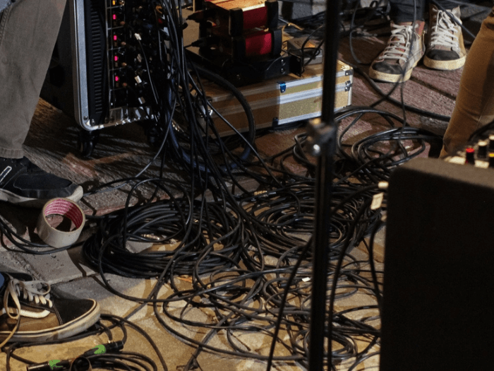 A tangle of black cables, connected to sound equipment.