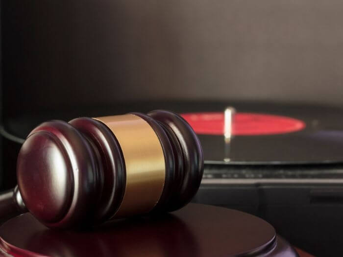 Judge's gavel in front of a vinyl record player.