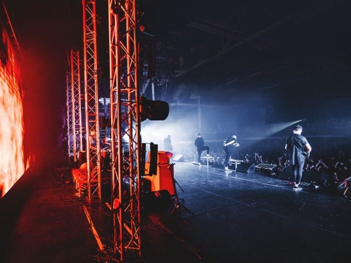 Backstage view of a band performing in a large venue.