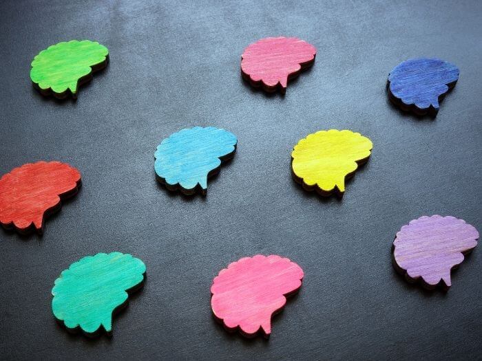 Cutout shapes of brains in different colours to indicate neurodiversity.