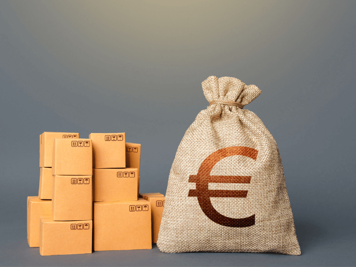 Stacked cardboard boxes next to a cotton sack with a large euro symbol on.