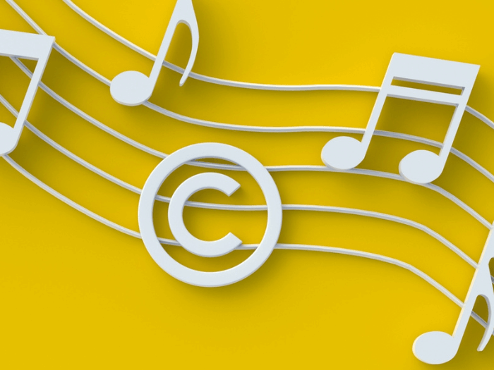 White music notes and a copyright symbol on a yellow background.