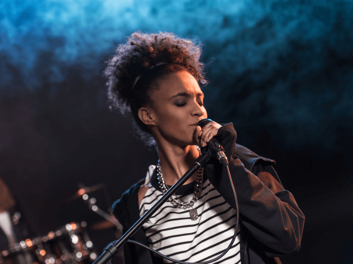 A young black vocalist performing on stage.