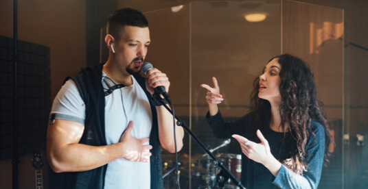 woman giving a vocal lesson to a young man