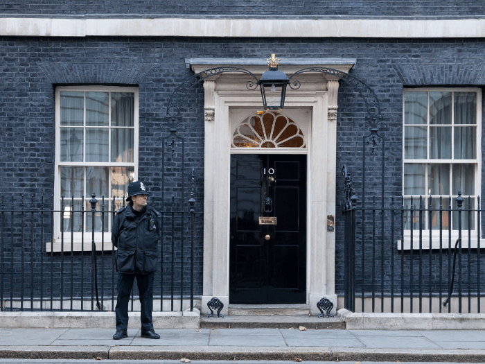 A policeman with hands behind his back in front of 10 Downing Street in London.
