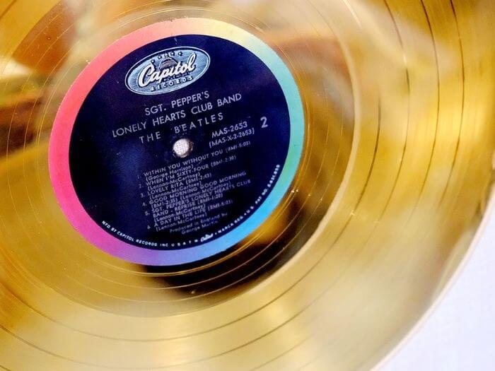 Close up of the track listing of SGT. Pepper's Lonely Hearts Club Band by the Beatles on a gold LP.