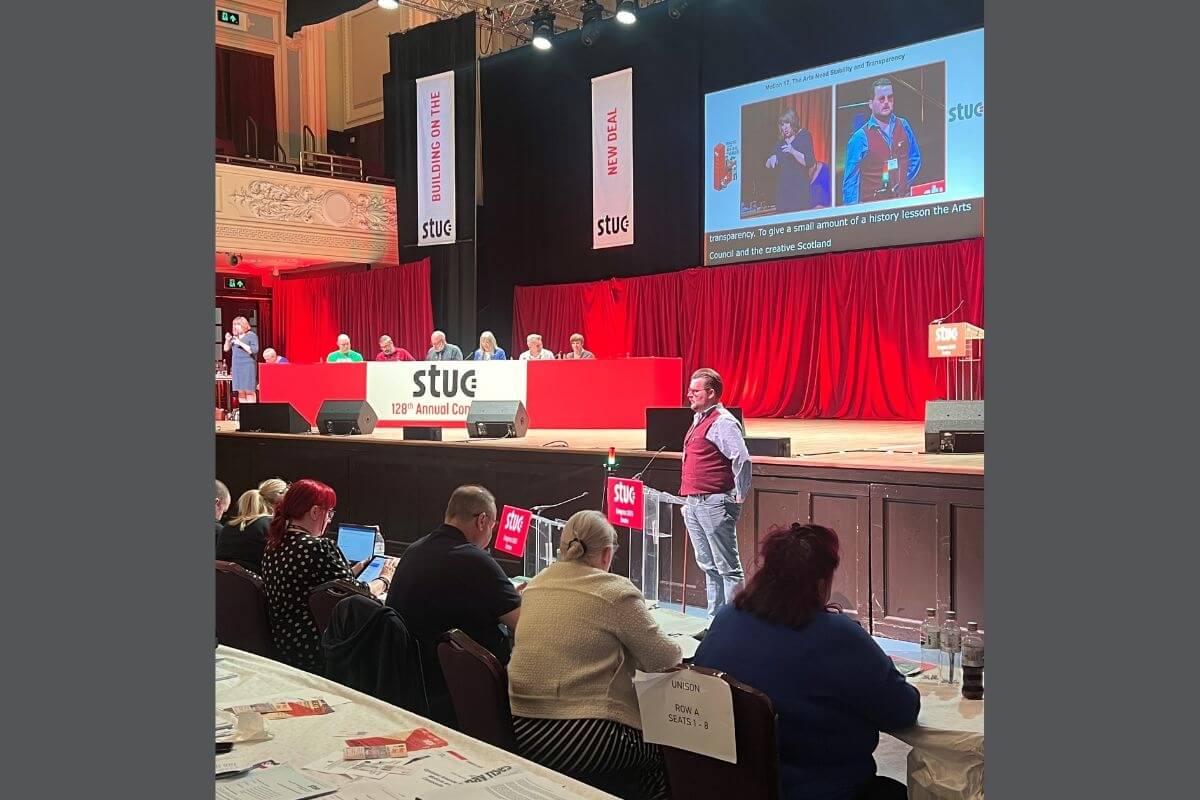 Ben Lunn at front of stage speaking to the audience at STUC 2025.