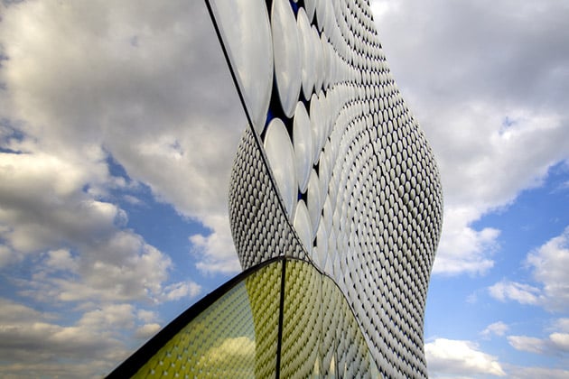 Close up of the Birmingham Bullring shopping centre with a sunny and cloudy sky reflected in the mirrors of the building