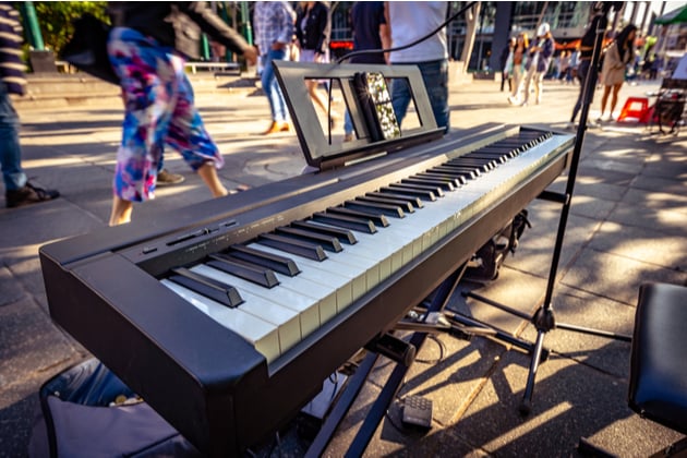 Photograph of a keyboard set up by a busker out in a busy open space