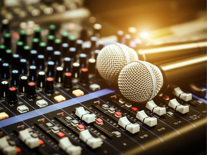 Close up of two microphones on a mixing desk in a studio.