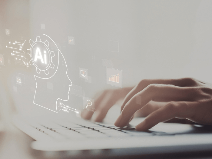 Hands typing on a computer keyboard using an AI program.