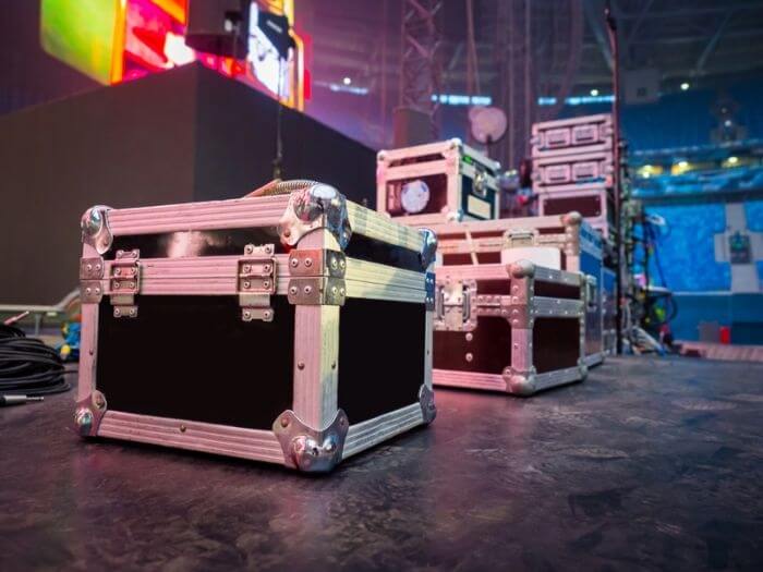 Instrument flight cases in front of a stage ready for set up.