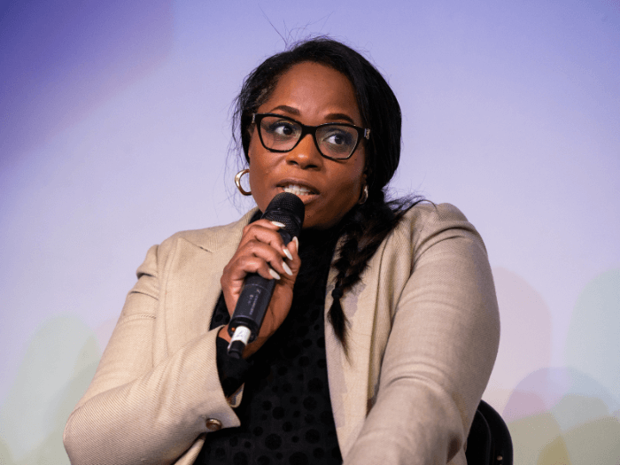 Charisse on stage speaking into a microphone at the Musicians’ Census wrap event.