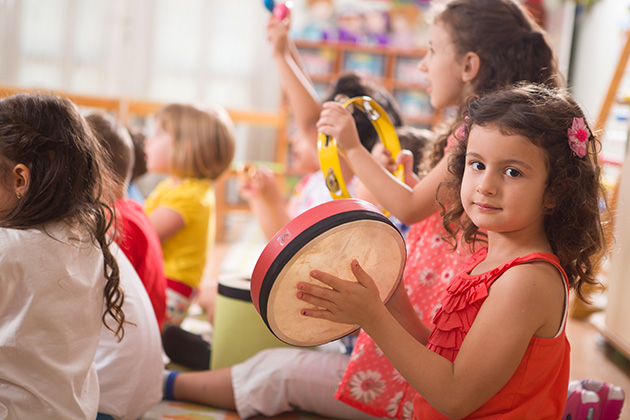 Photo of children learning on percussion instruments in a group setting.