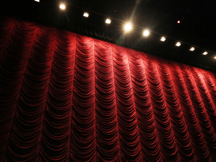 Closed red theatre curtain over stage.