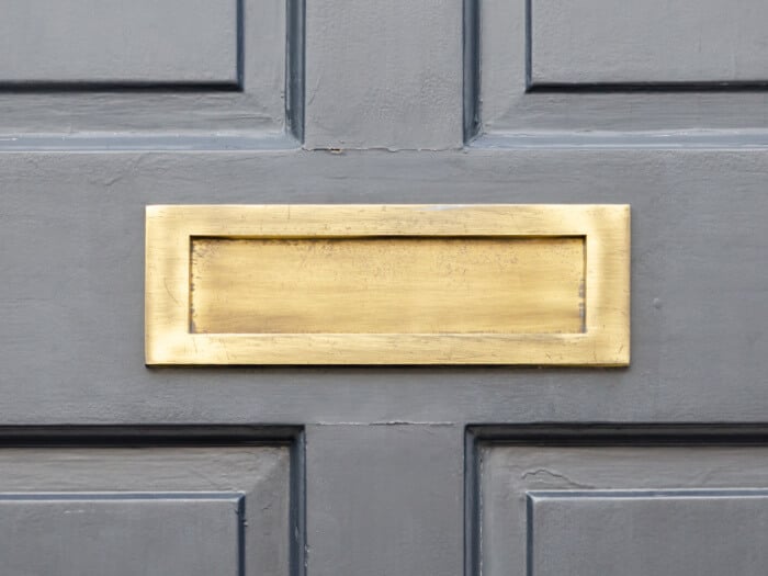Grey painted door with metal letter box
