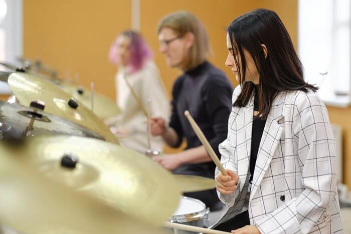 Three teenage students at a drum lesson.