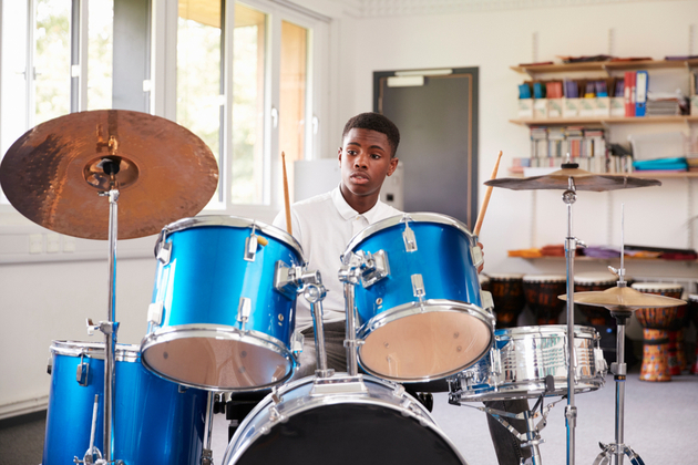 Photograph of a young percussion student sat behind a drum kit.