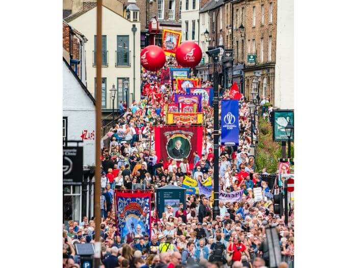 Last year's parade, hundreds of people walking down the narrow historic main street, holding large colourful banners and balloons.