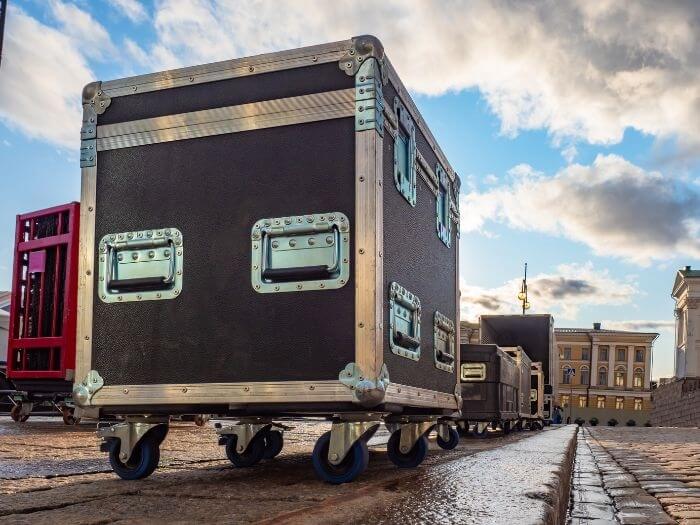 Touring crates lined up outside on a cobbled street.