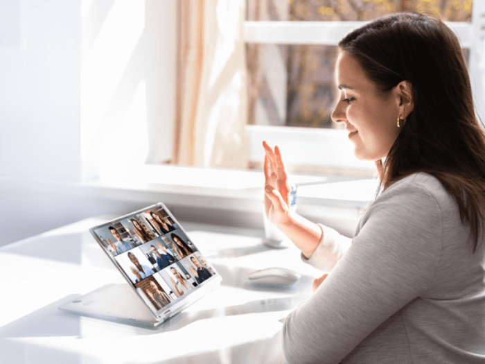 Woman smiling as she joins an online meeting from her tablet.