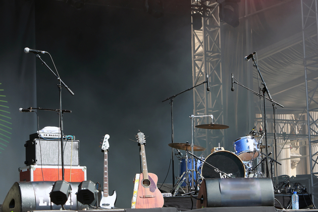 Photograph of an empty concert stage, with instruments set up to play but no musicians present.
