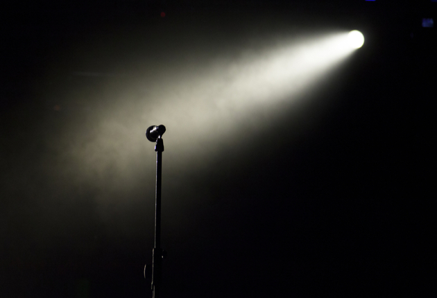 Empty stage in the dark with the microphone in the spotlight