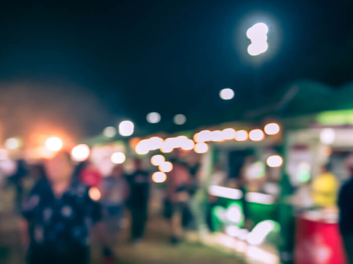 Blurred bright lights and colours at night implying food trucks at a festival