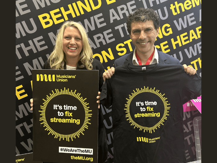 Naomi Pohl and Alex Sobel MP holding black Musicians’ Union t-shirts that say ‘It’s time to fix streaming’.