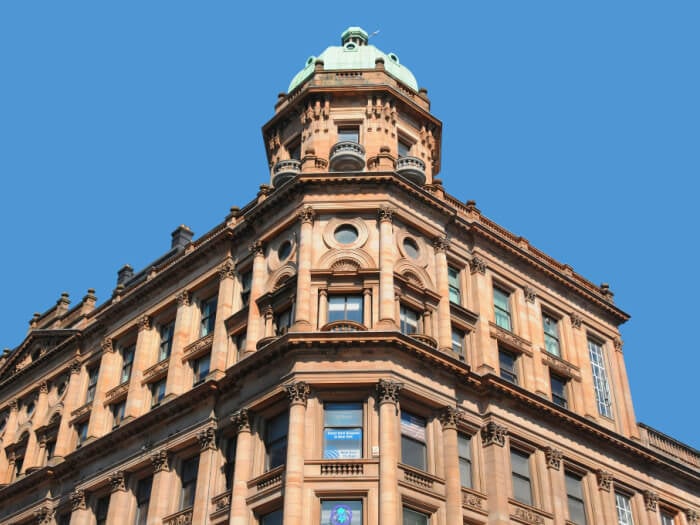 Photo of a tall and distinctive building in Glasgow against a bright blue sky.