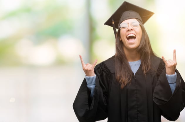 Photograph of a happy graduate making rock star hand gestures