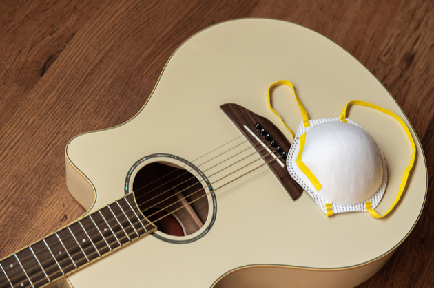 Photograph of a mask on top of a guitar