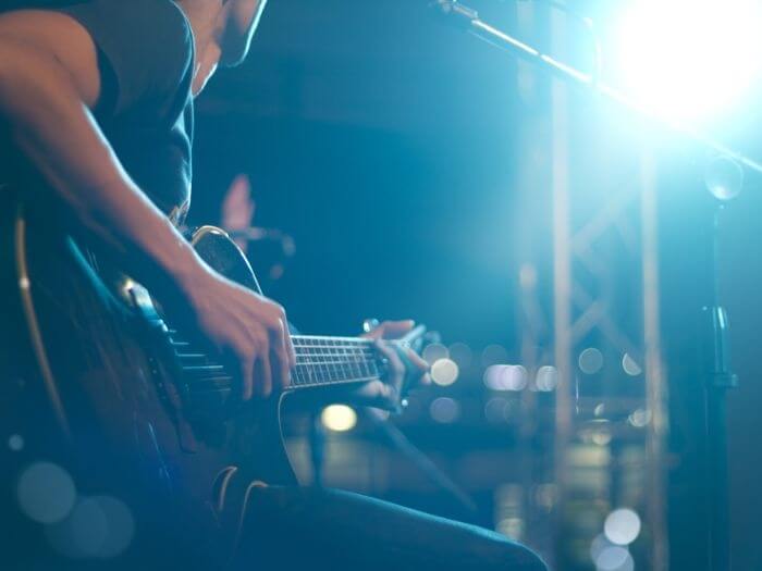 Close up of guitarist on stage in soft blur focus.