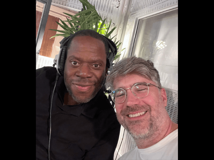 Selfie of Harry wearing headphones and smiling next to his friend and colleague, trumpeter Matt Roberts.