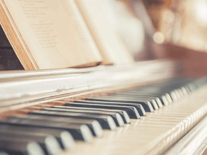 Close up, side view, of an old piano with ivory keys.