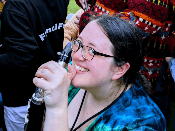 Musician Kat Browning holding a clarinet and smiling.