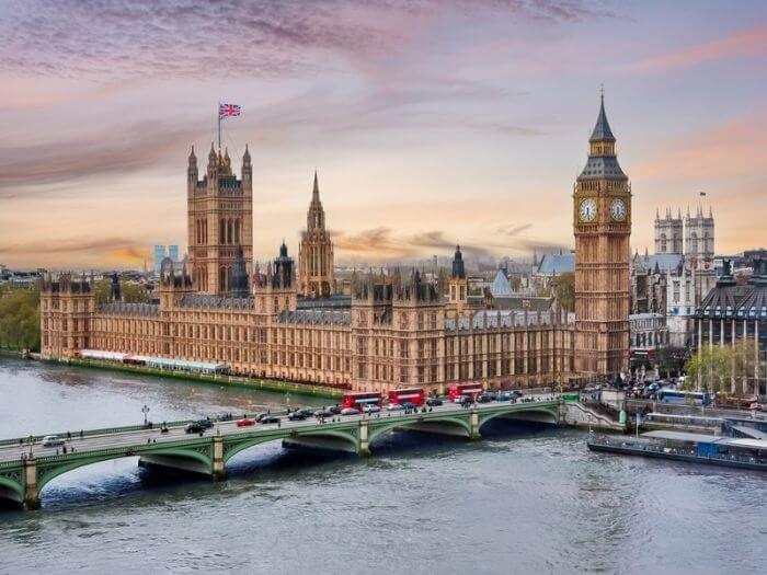 London cityscape with Houses of Parliament and Big Ben tower at sunset.